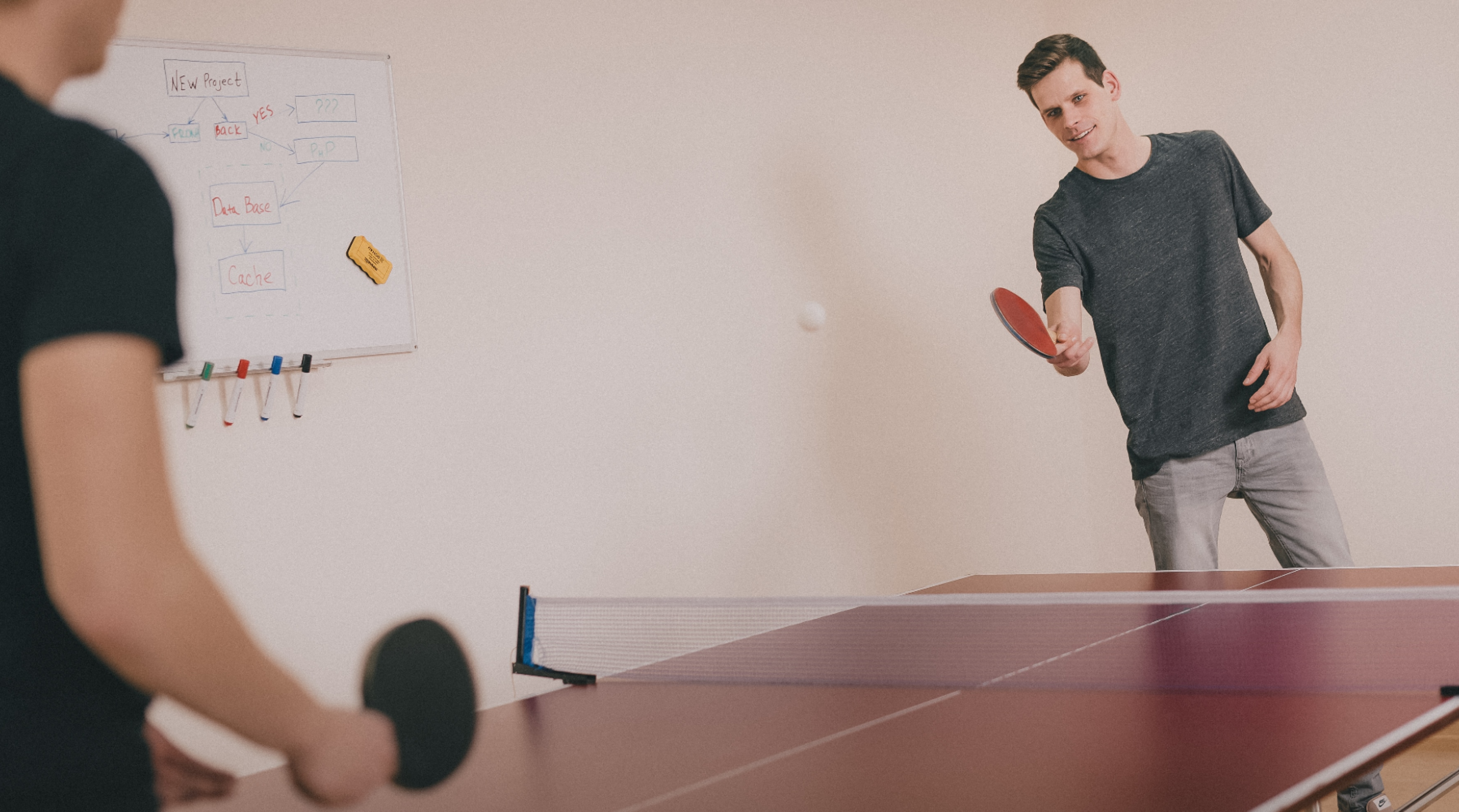 two men playing ping-pong inside room