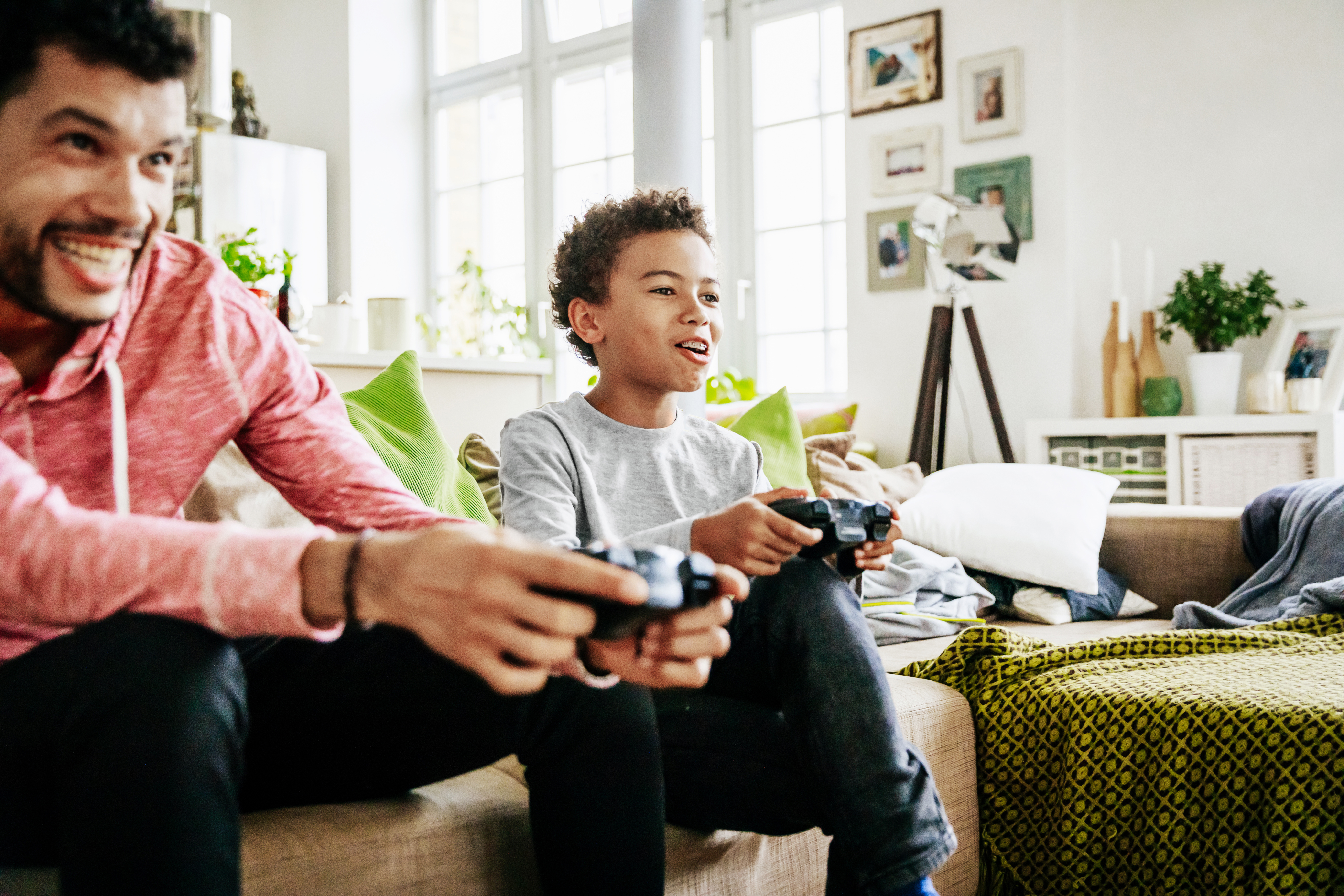 Young Boy Enjoying Himself Playing Video Games With Dad