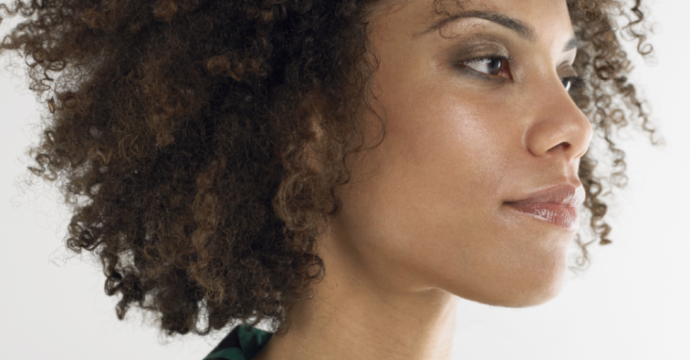 Closeup of a young afro woman with curly hair against white background
