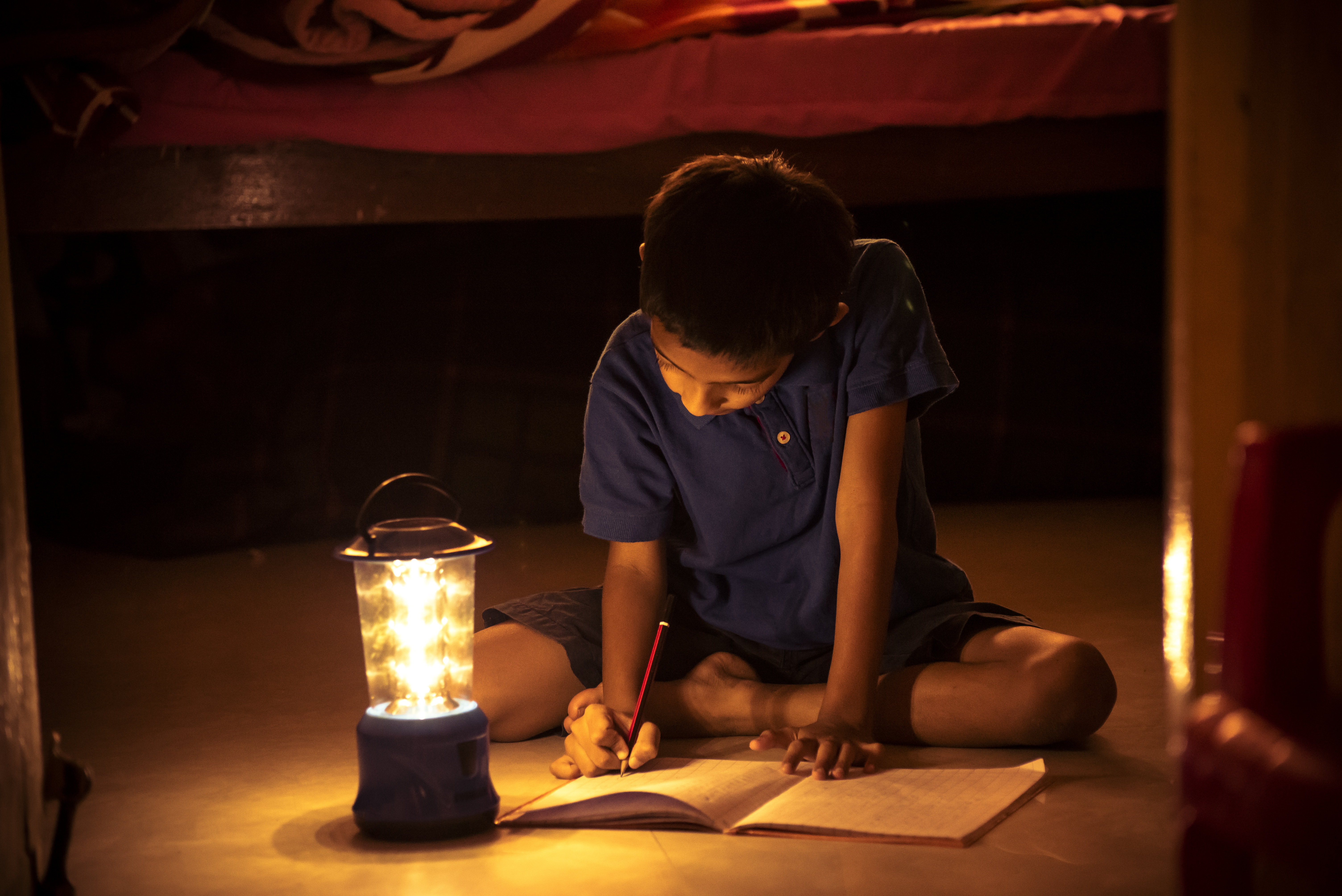 7 years Indian Boy studying under lamp