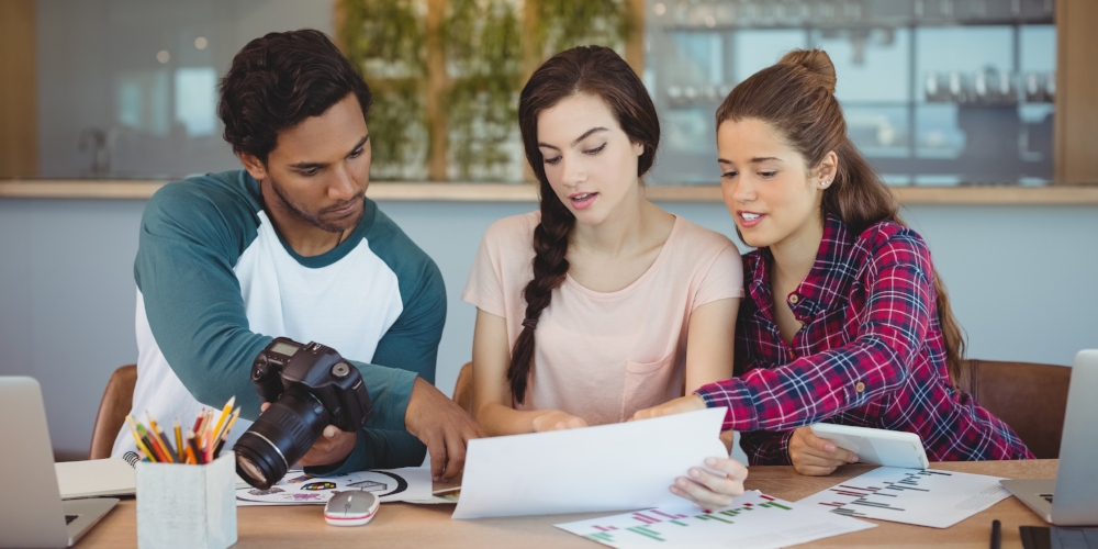 Graphic designers sitting at table and interacting