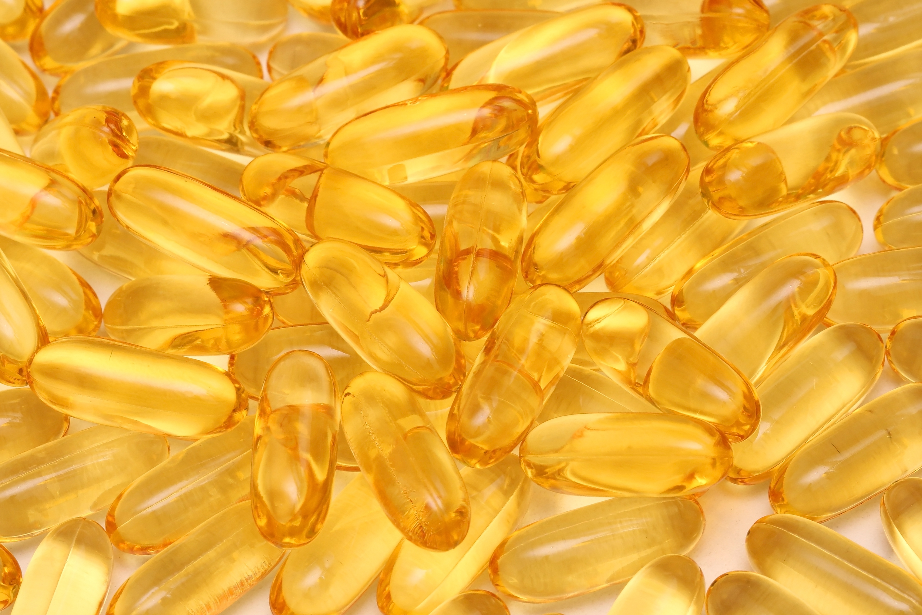 Large pile of omega 3 fish oil supplement gel capsules