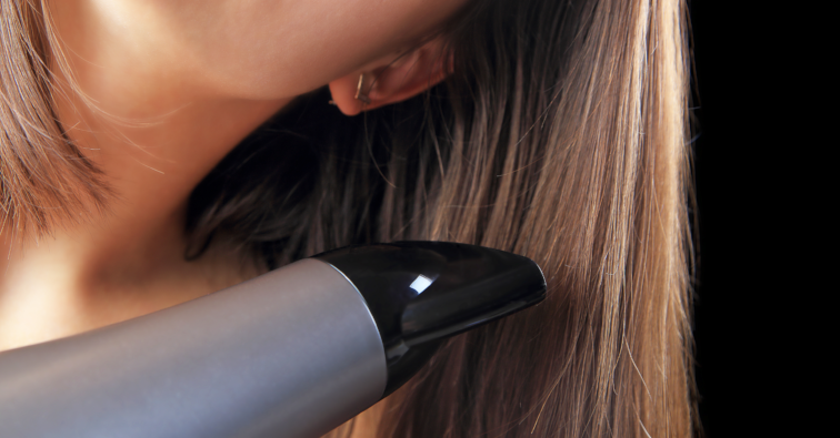 Hairdryer and brown hair isolated on black