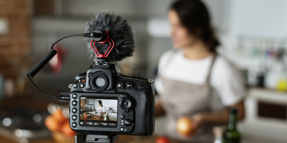 Female vlogger recording cooking related broadcast at home
