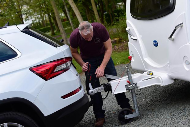 Man attaching caravan to car