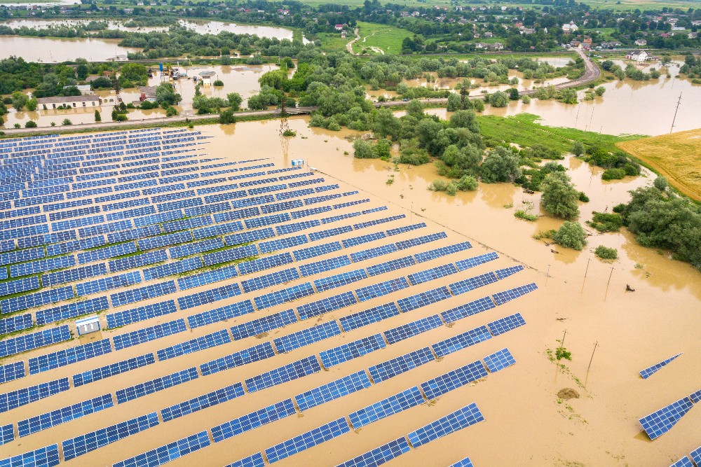 Aerial view of flooded solar power station with dirty river water in rain season.