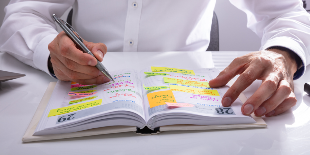 Businessman Writing Schedule In Diary