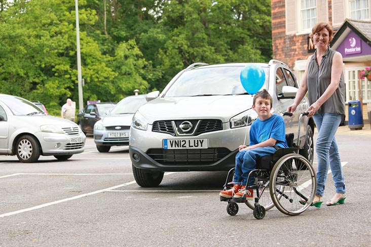 Lady pushing child in wheelchair