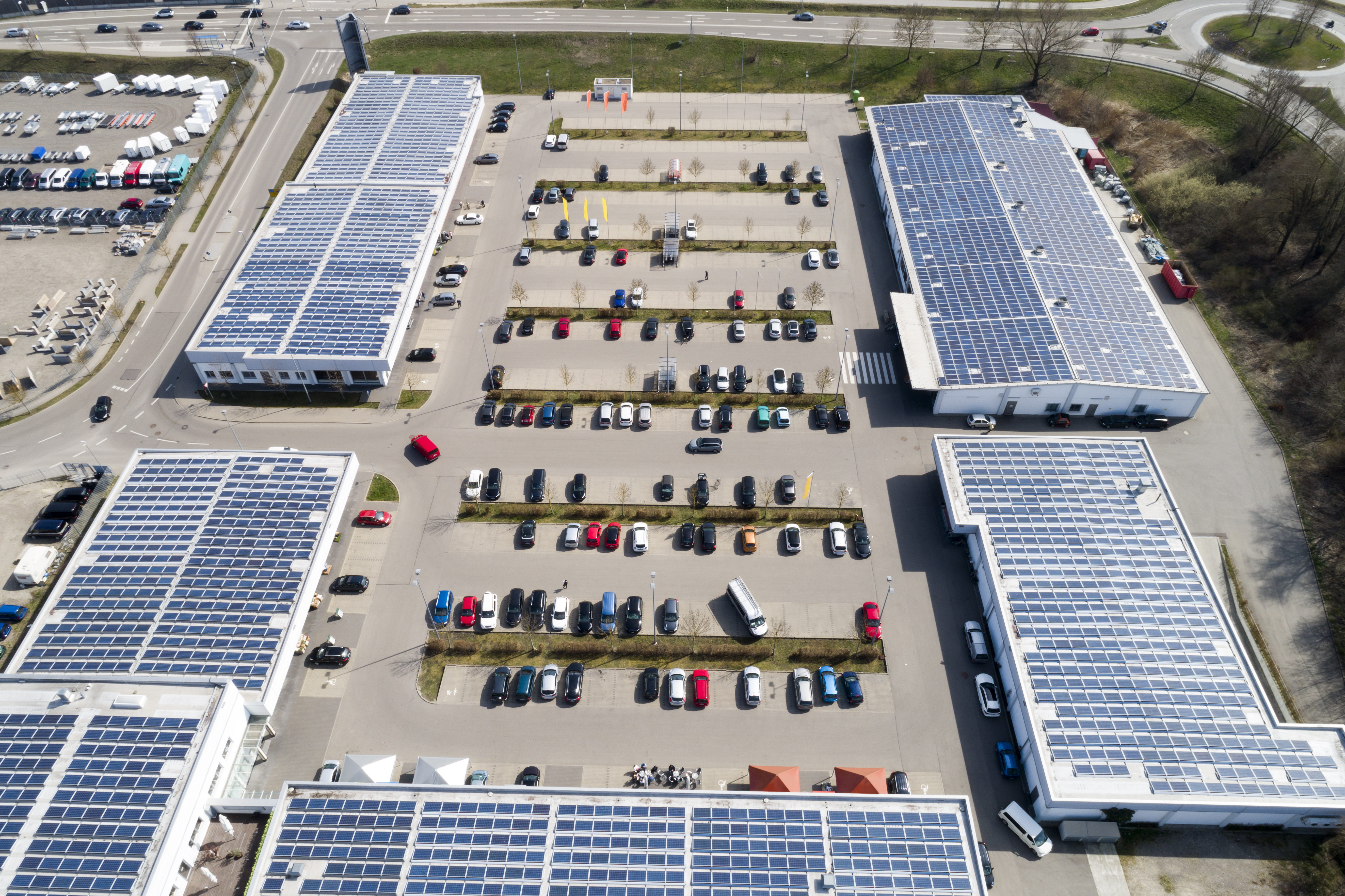 Shopping mall with solar panels and parking lot from above