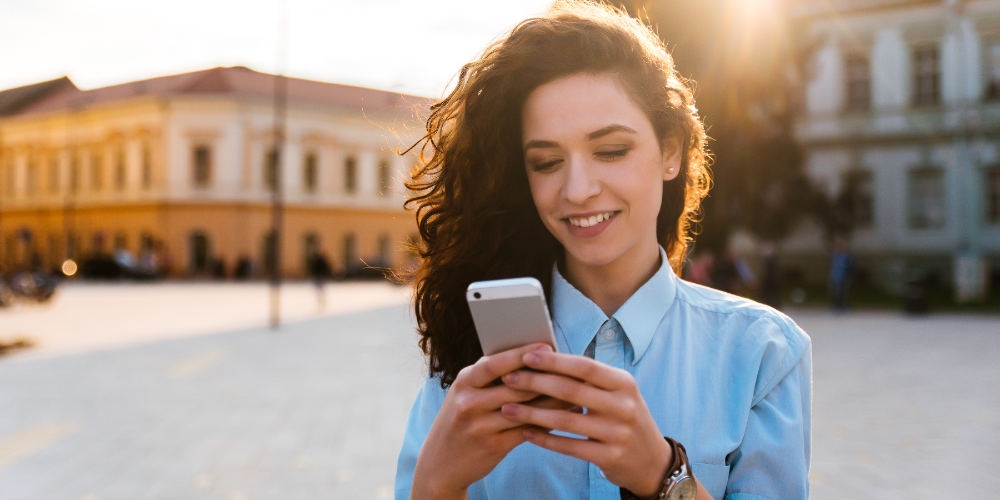 Portrait of a beautiful smiling woman using a mobile phone outdoors