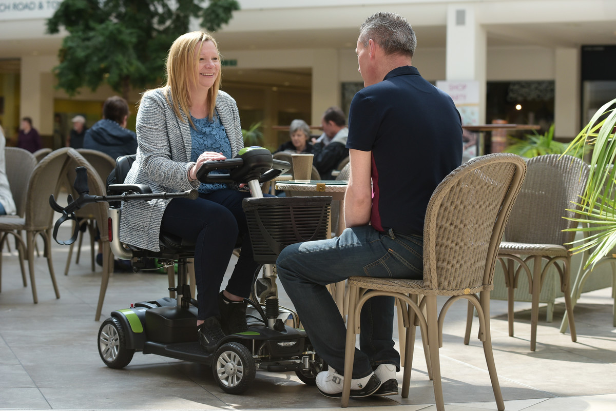 Couple chatting in cafe with mobility scooter.jpg