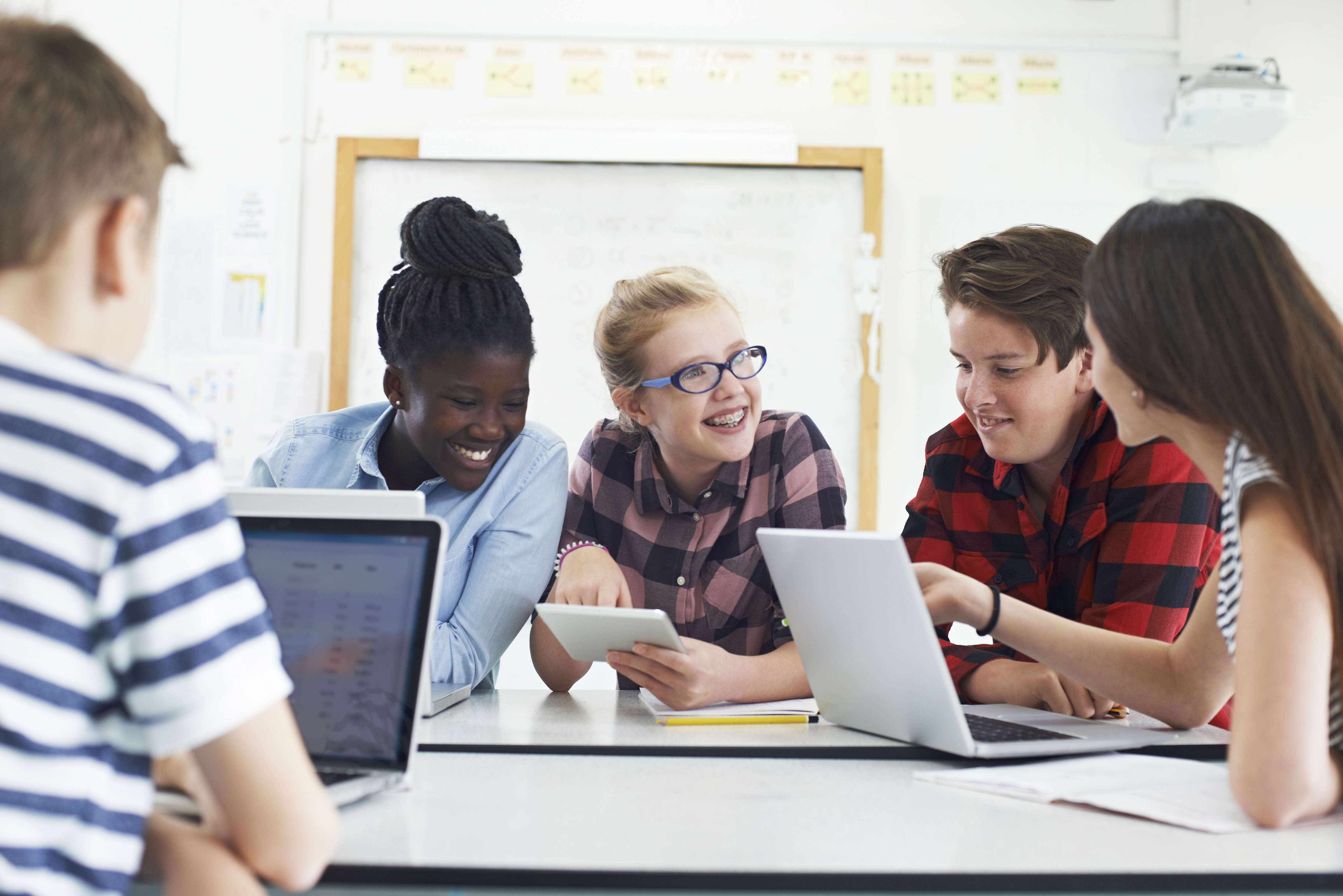 Group Of Teenage Students Collaborating On Project In IT Class