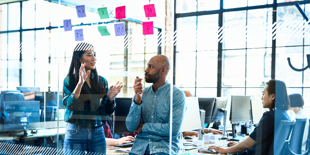 Confident Chinese woman talking to colleague in office