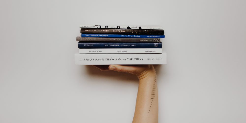 person holding pile of books