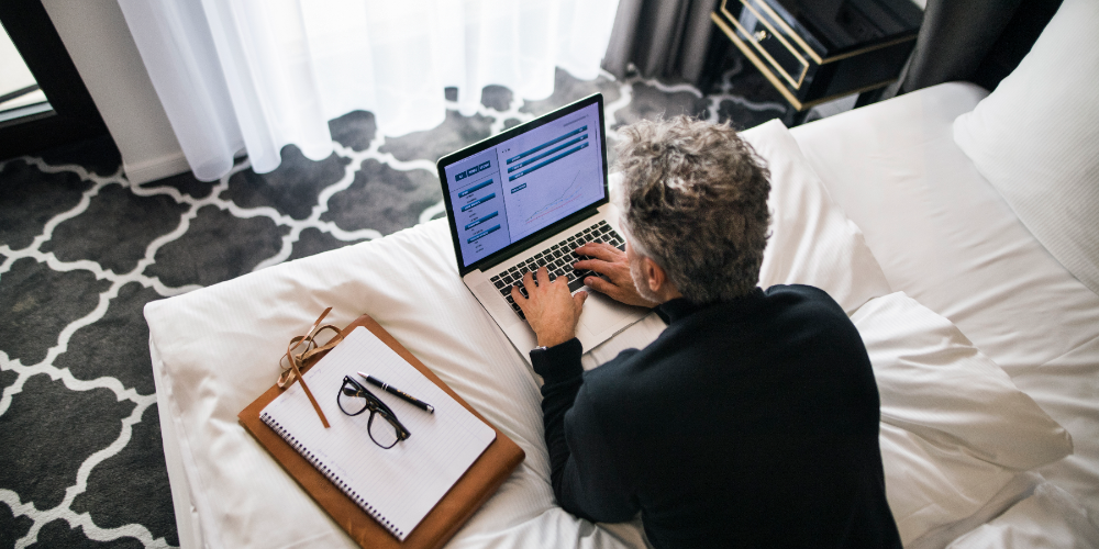 Mature businessman with laptop in a hotel room.