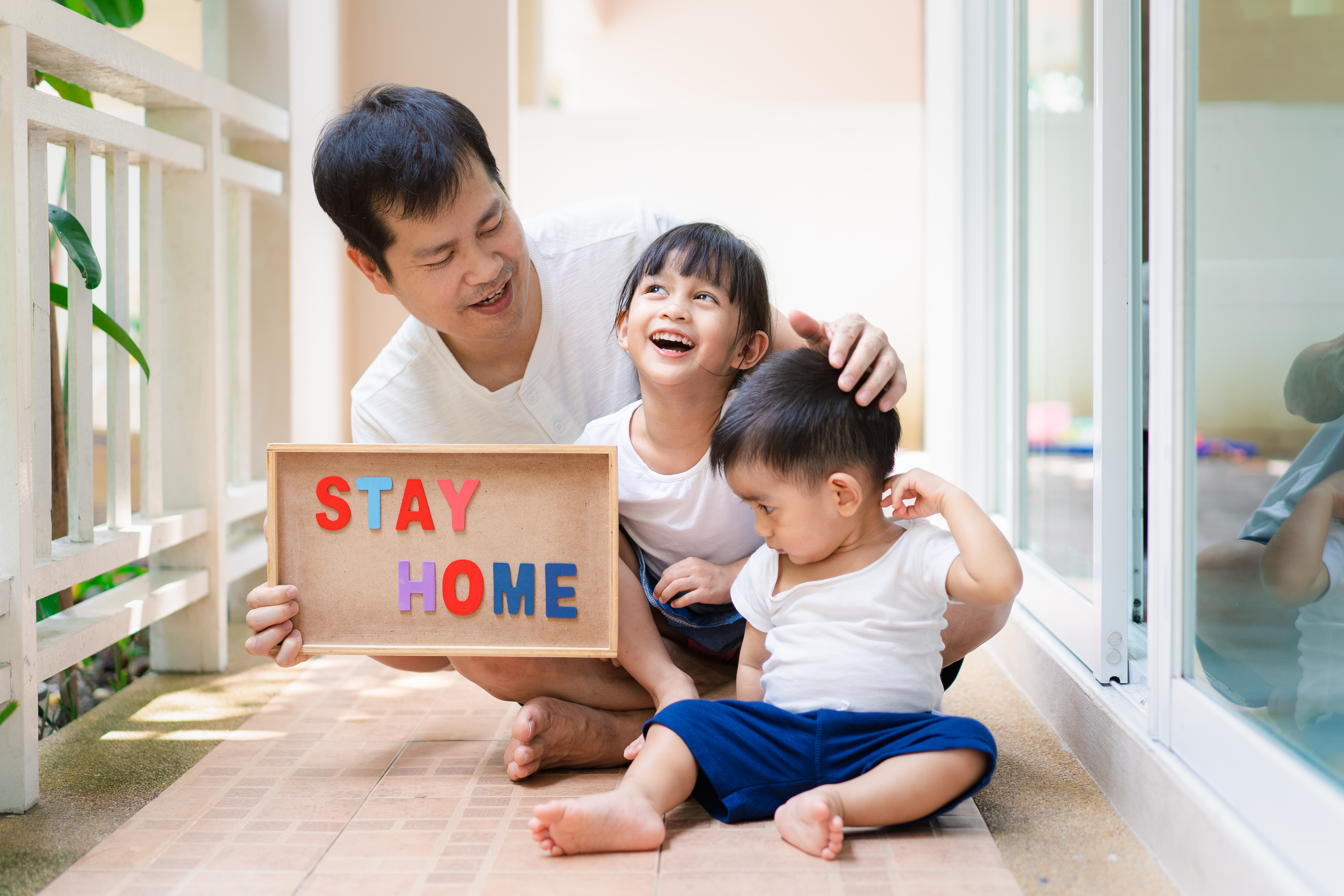 Father and children are holding the "stay home" board.jpg