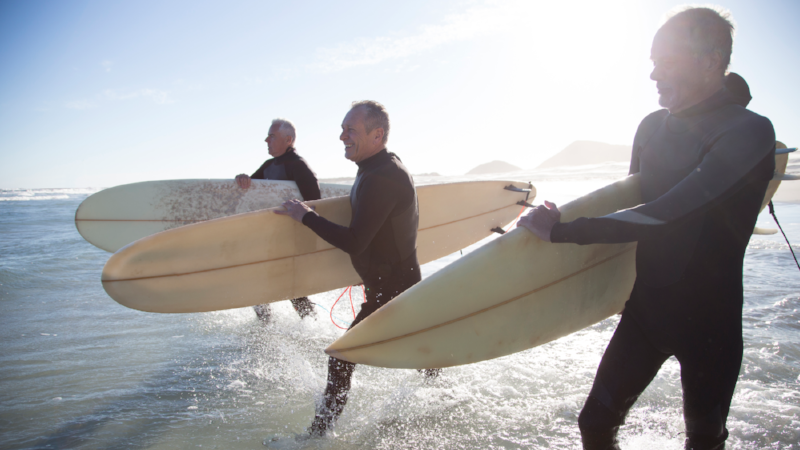Senior surfers on a beach at sunset