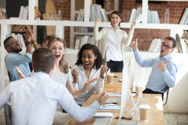 Group of co-workers celebrating in meeting room