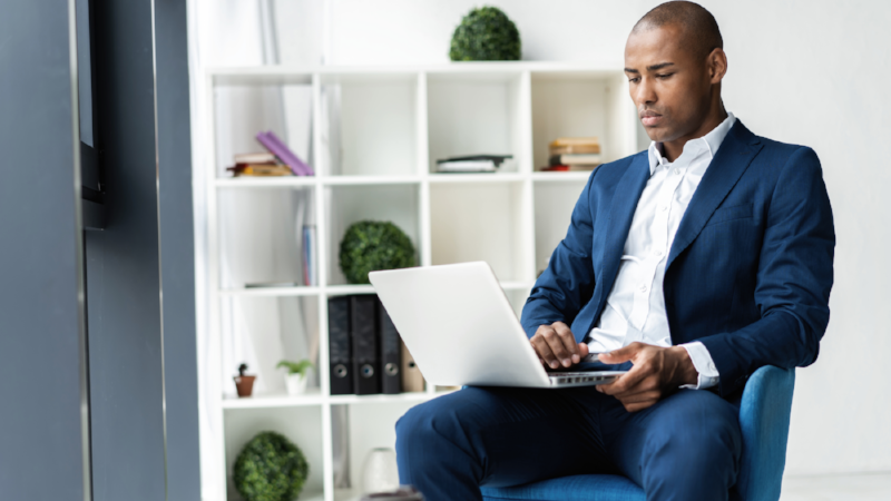 Image of african american businessman working on his laptop. Handsome young man at his desk.