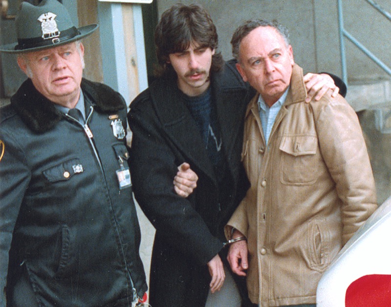 Jesse Friedman puts his arm around his father, Arnold Friedman as they are escorted in handcuffs by police