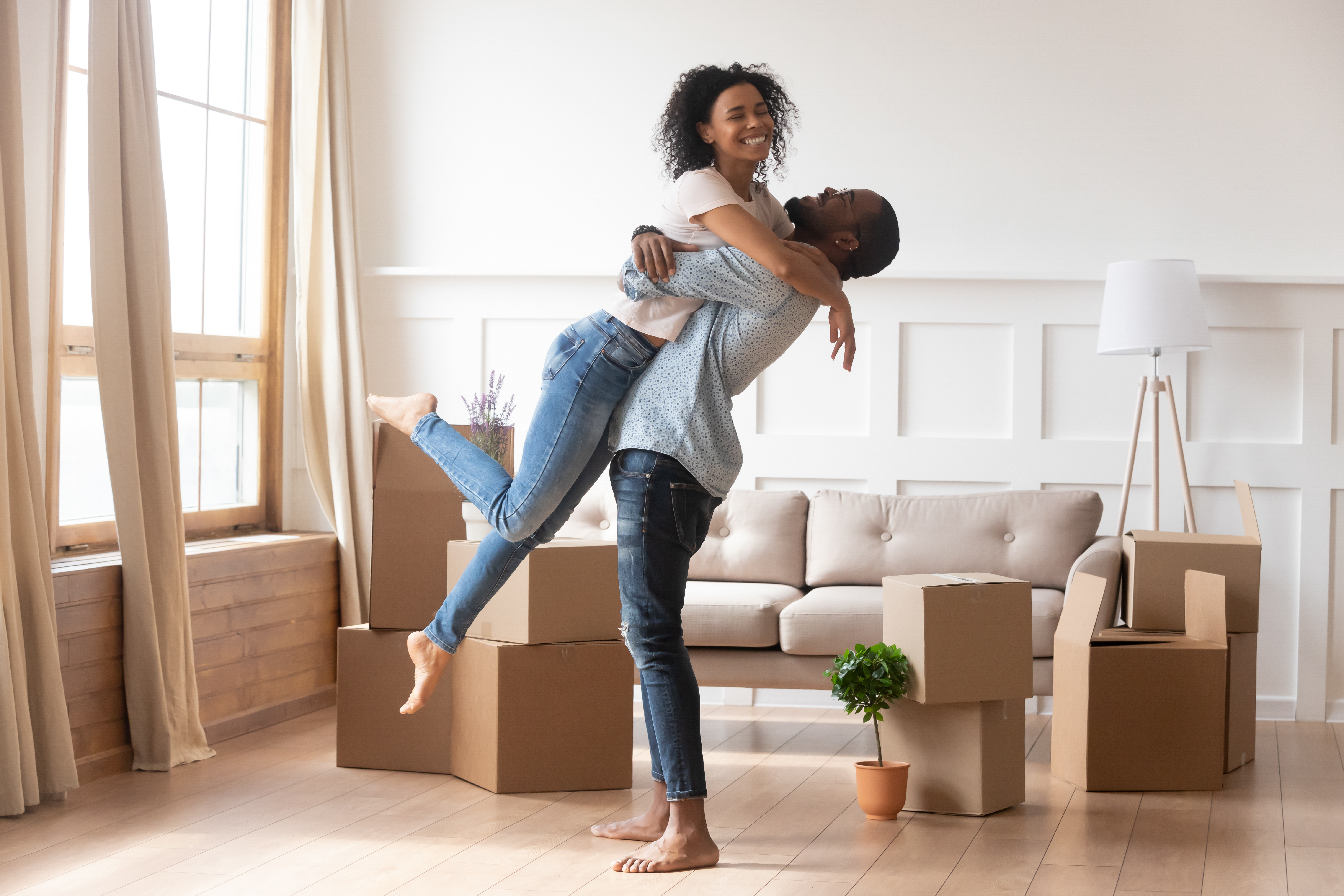 Happy african couple first time home buyers celebrate moving day