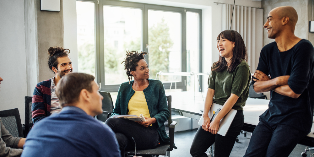 Réunion de travail entre collègues autour d'une femme hilare